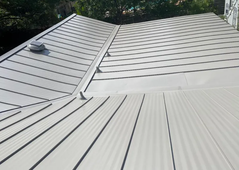 Solar attic fan installed on a metal roof for Roof Ventilation in Williston Park